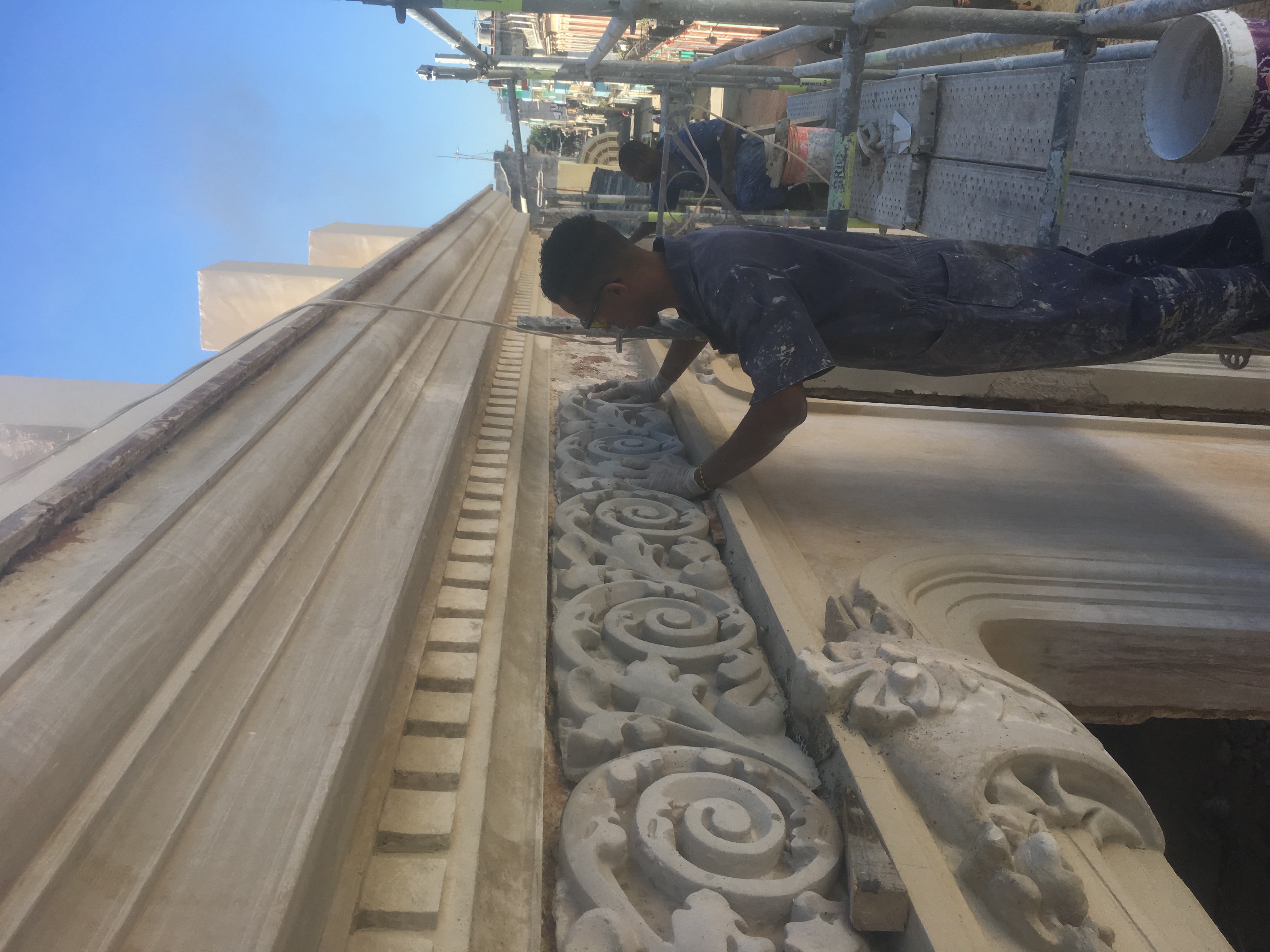 Craftsperson restoring facade ornamentation by hand